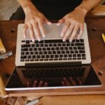 Contractor using job management software on laptop