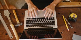 Contractor using job management software on laptop